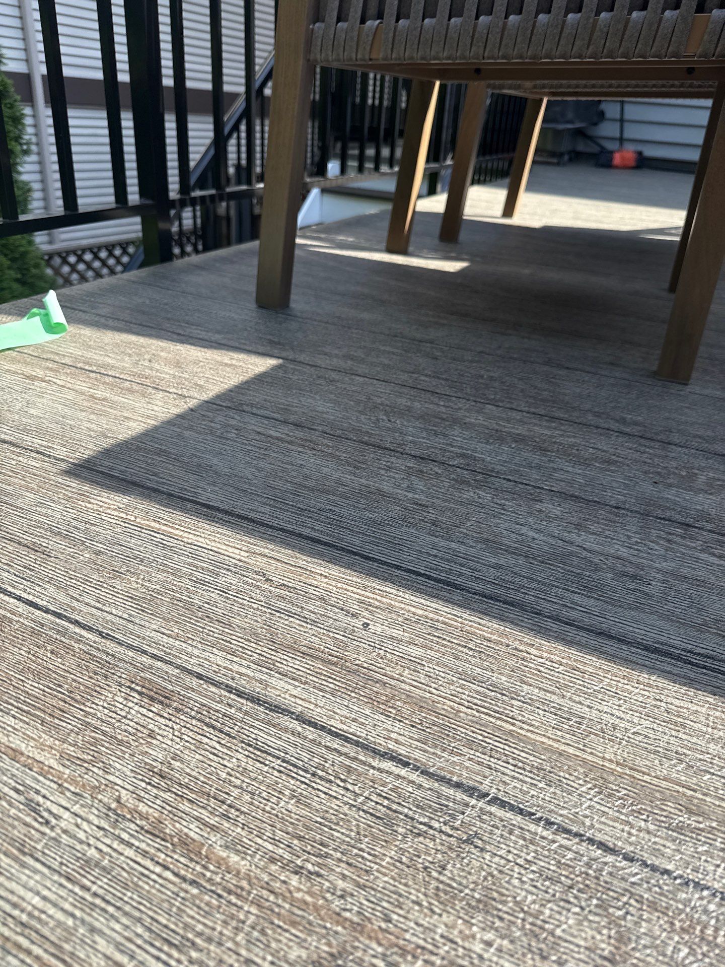 Close-up of Valordek Walnut Plank vinyl decking showing the printed wood grain pattern that paint would cover
