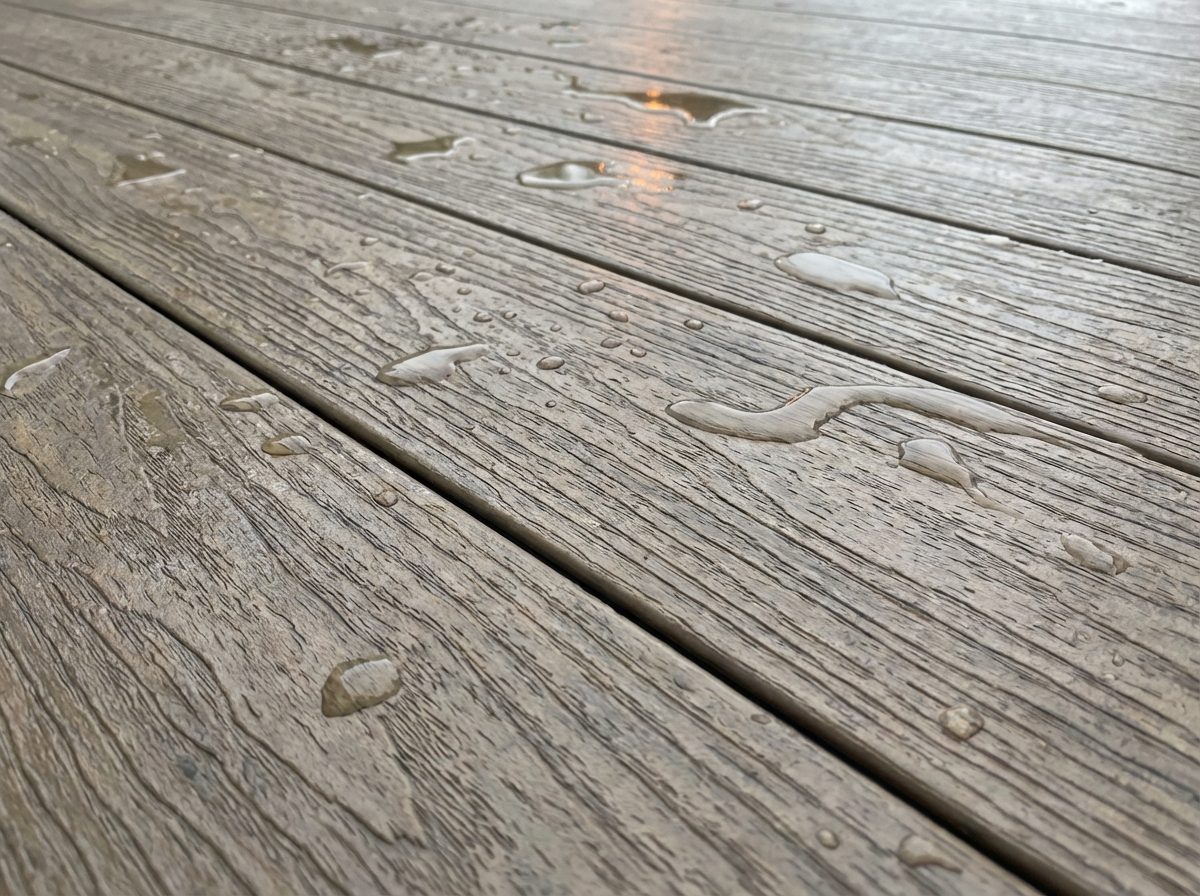 Vinyl deck membrane surface with water droplets showing slip-resistant texture in wet conditions