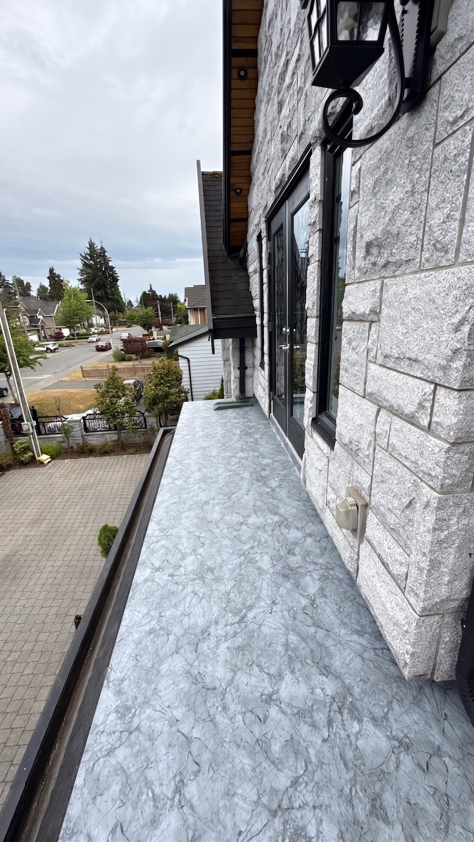 Valordek Marble Grey vinyl decking membrane on an elevated balcony showing the deck edge and door threshold