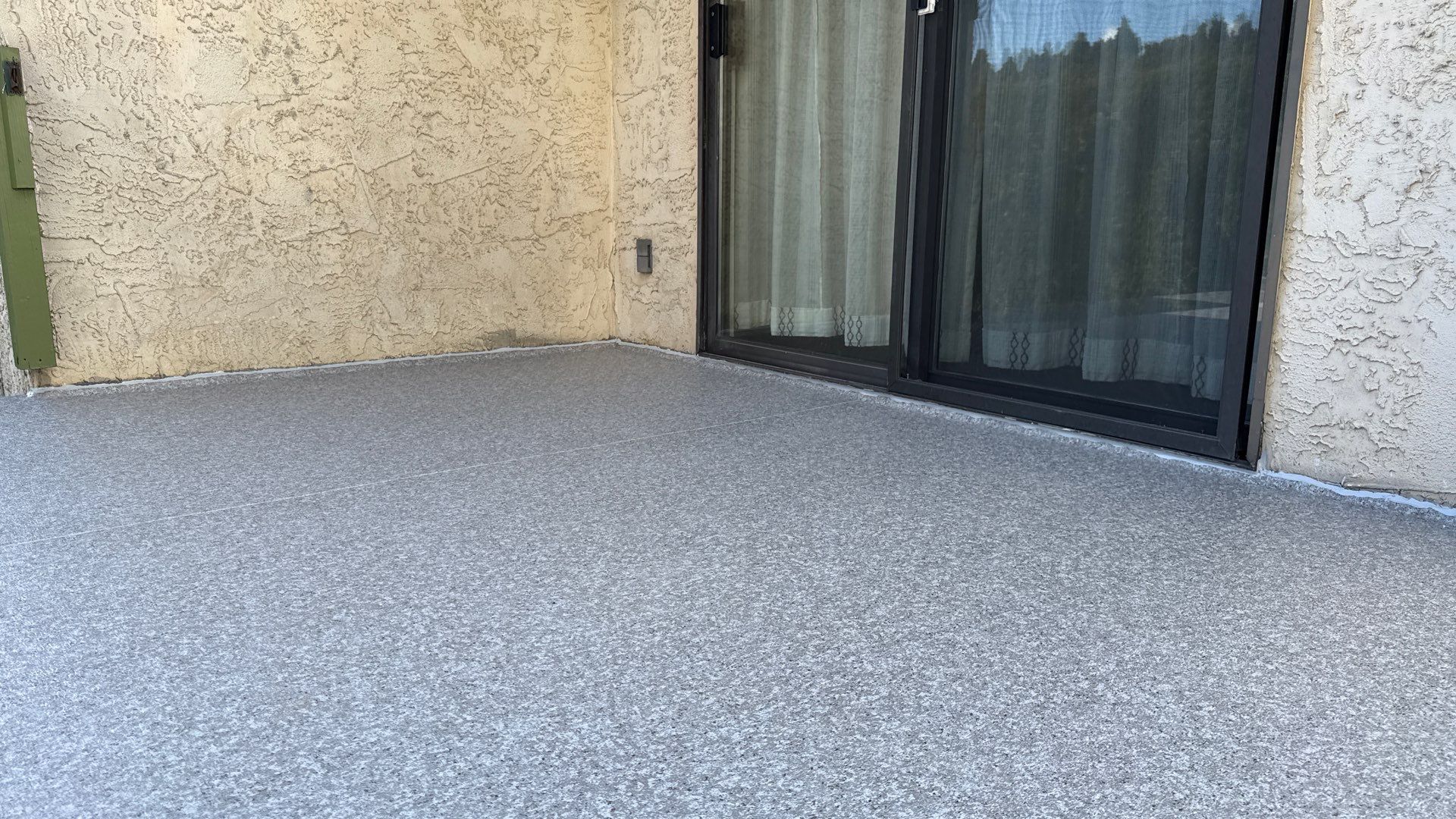 Valordek Grey Stone vinyl decking membrane meeting a patio door on a balcony