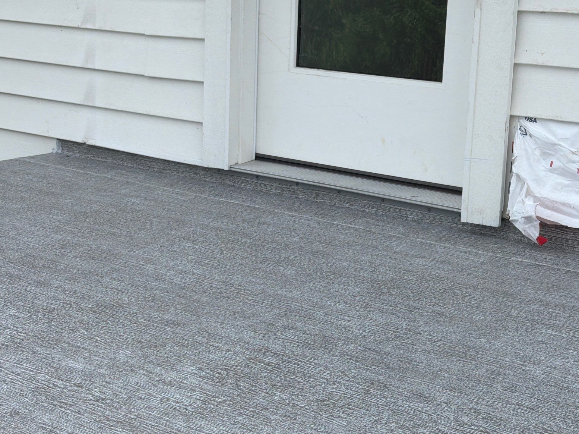 Valordek Smoke Grey vinyl decking membrane meeting a patio door threshold