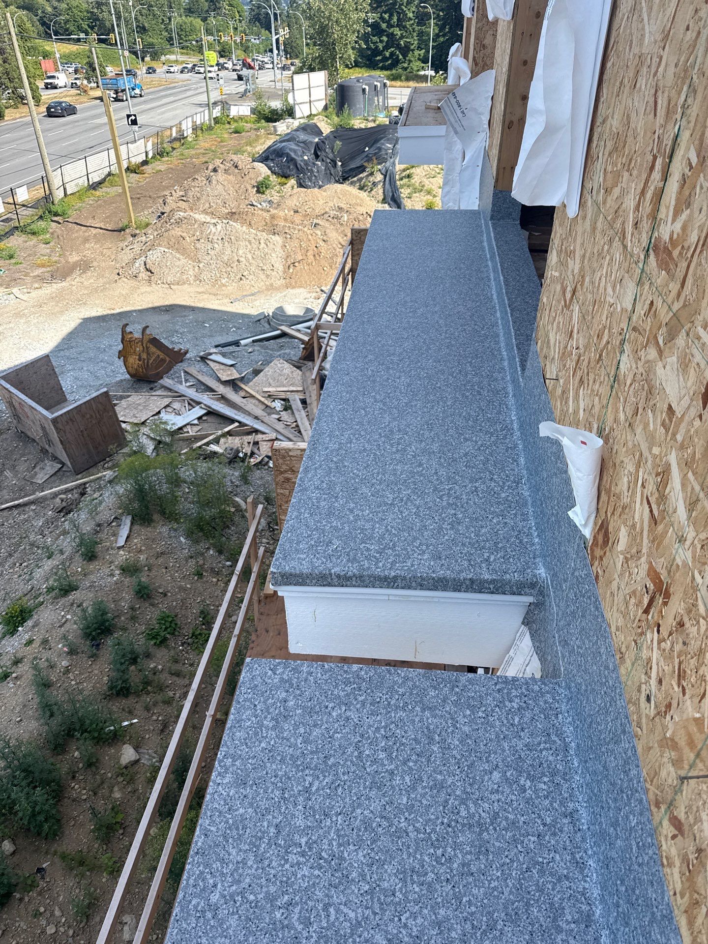 Valordek Grey Stone vinyl membrane turned up the wall and wrapped over the edges of an upper-level deck during construction