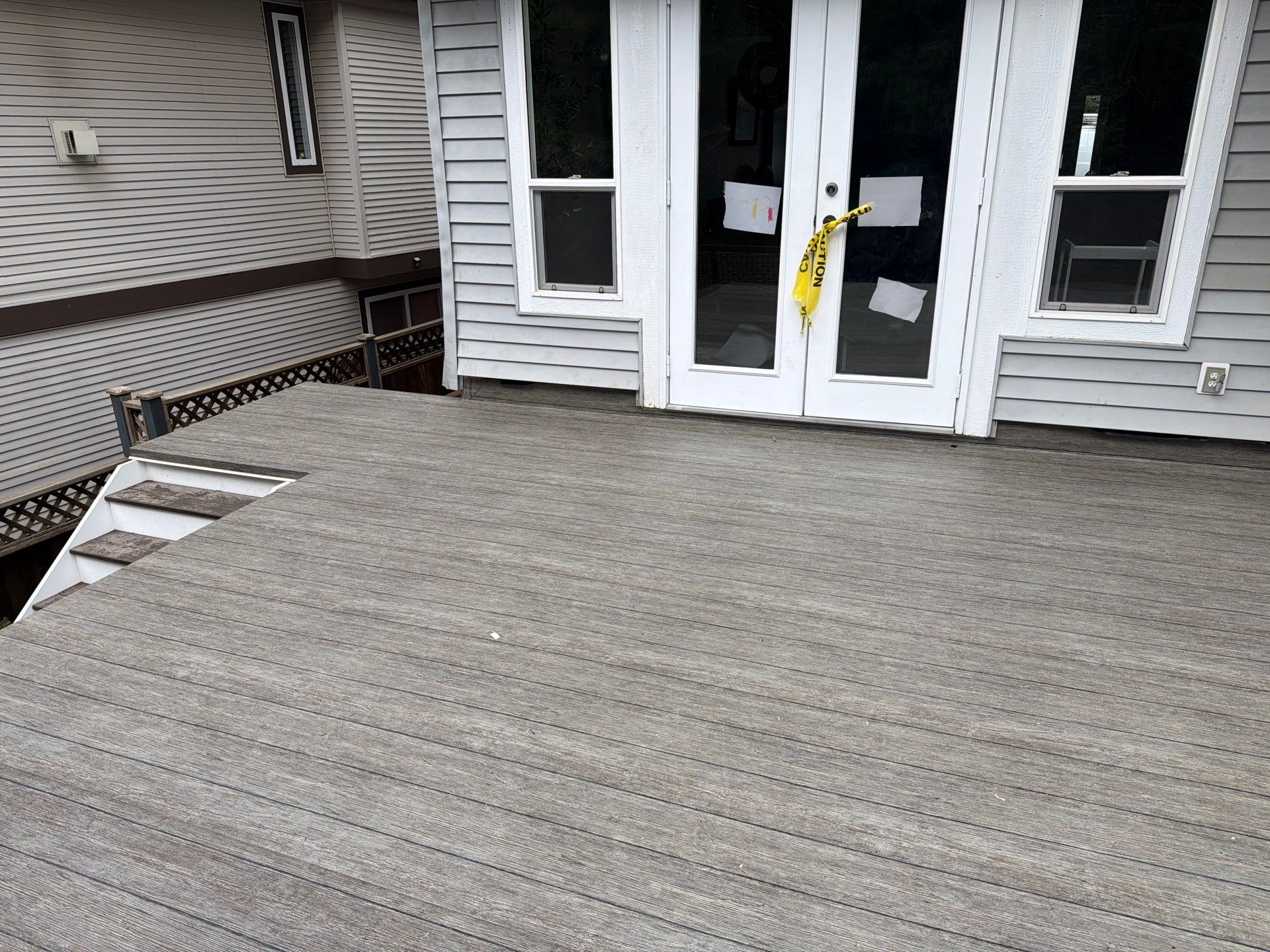 Valordek Walnut Plank vinyl decking membrane on a deck outside a set of French doors