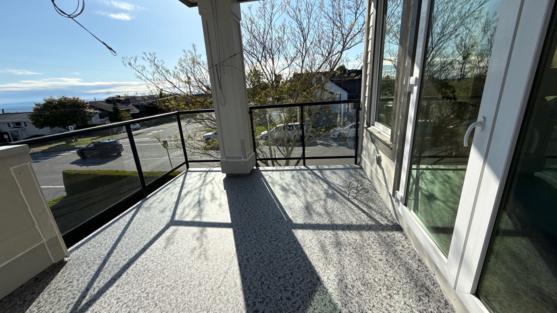 Valordek Madison Grey vinyl decking membrane on a balcony with glass railings